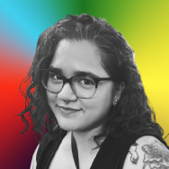 Black and white photo of a smiling woman wearing glasses and long curly hair.